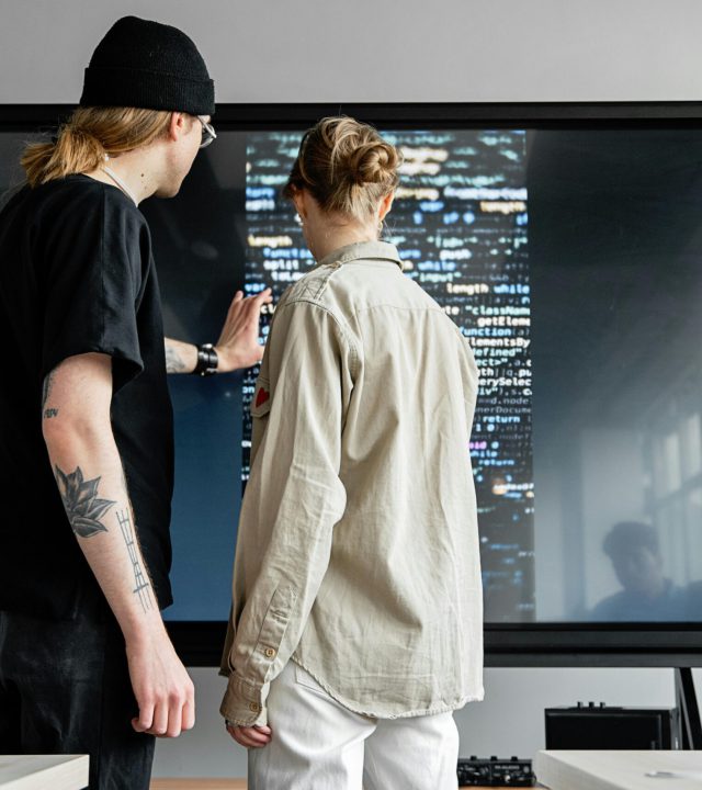 Two professionals collaborating on software development in a modern indoor setting.